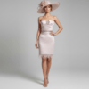 Vestido corto rosa nude para invitada de boda con escote palabra de honor y detalle de plumas en el bajo