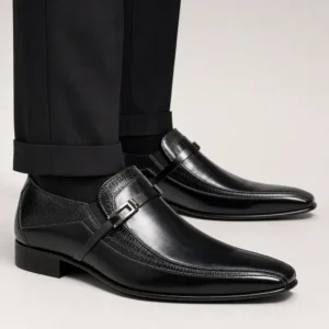 Mocasín negro de ceremonia para hombre en piel con adorno metálico y detalles texturizados, perfecto para bodas y eventos elegantes